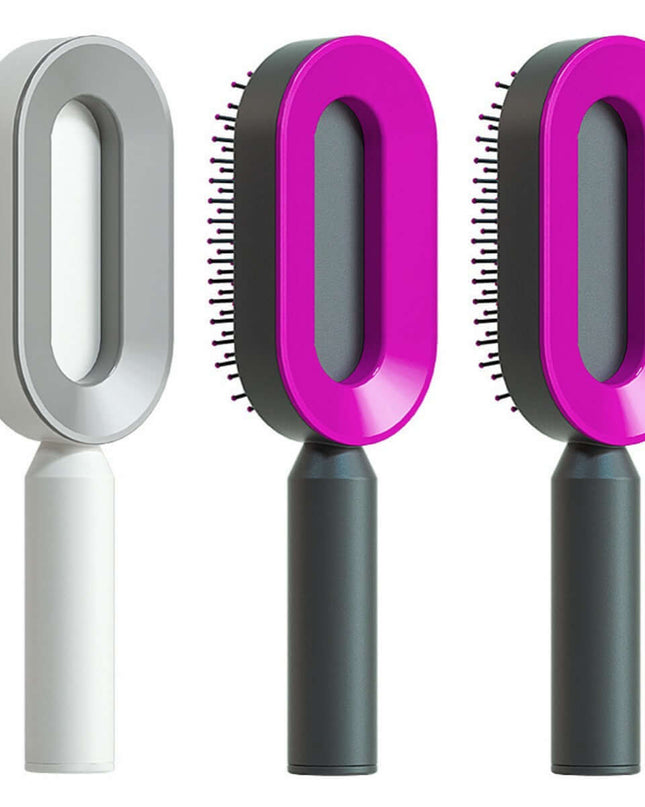 Three grooming brushes with pink and gray handles on a white background