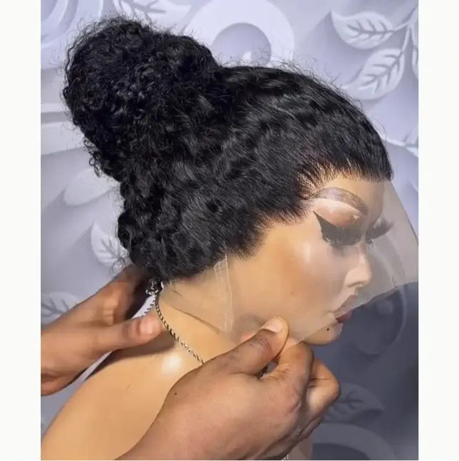 Person adjusting a black lace wig on a mannequin head against a decorative background.