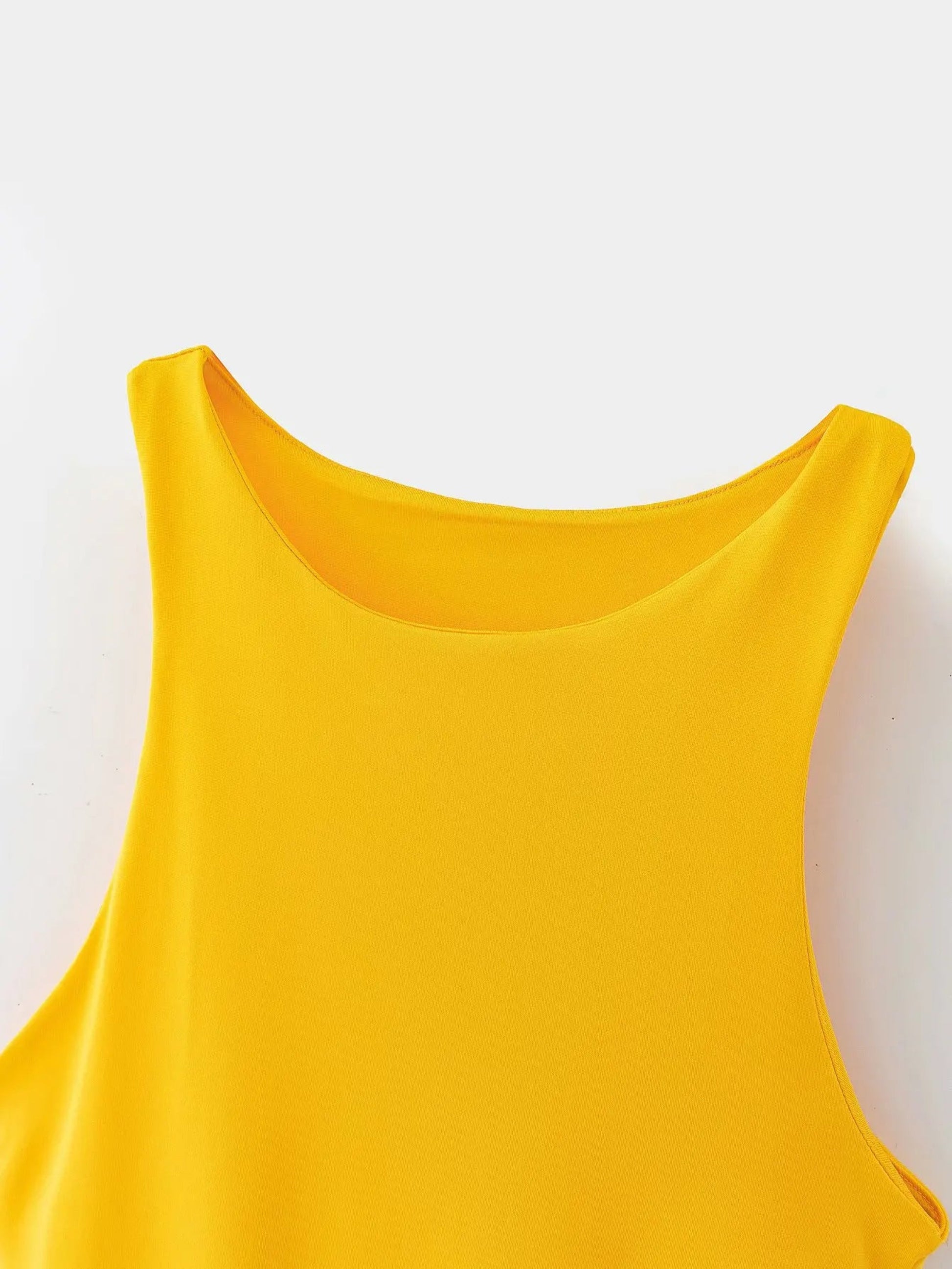 Yellow sleeveless top on a white background