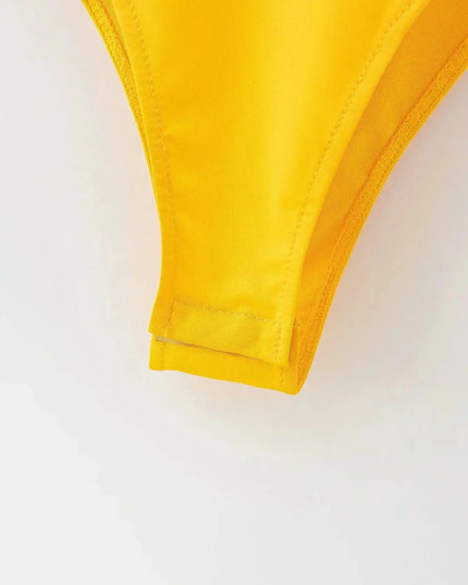 Close-up of a yellow bikini top on a white background