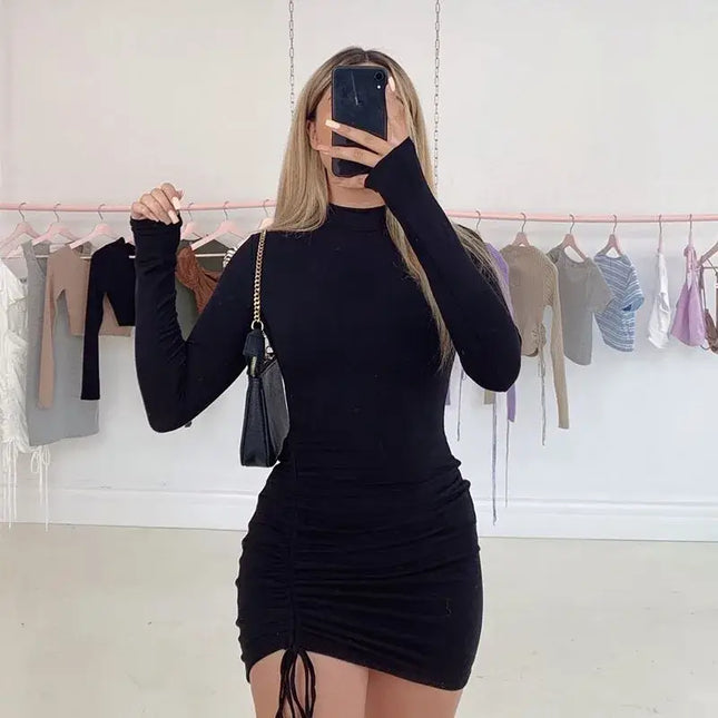 Woman wearing a Women’s Long Sleeve Ruched Bodycon Turtleneck Mini Dress in black, showcasing its stylish design and fit.