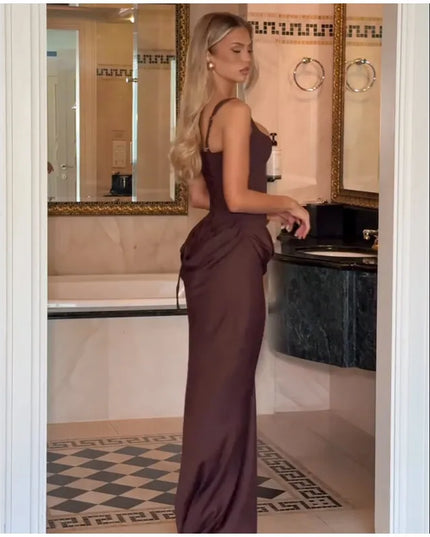 Brown pleated maxi dress showcasing a sleek silhouette in a stylish bathroom setting.