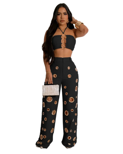 Woman wearing a black outfit with patterned pants on a white background