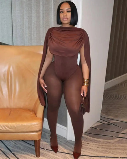 Woman in a brown outfit standing in a room with a beige couch.