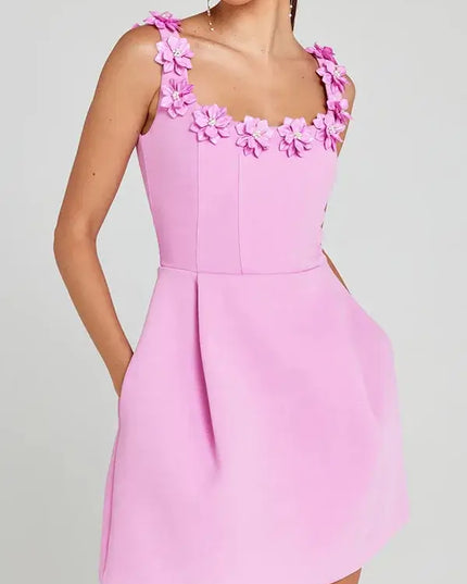 Pink dress with floral straps on a gray background