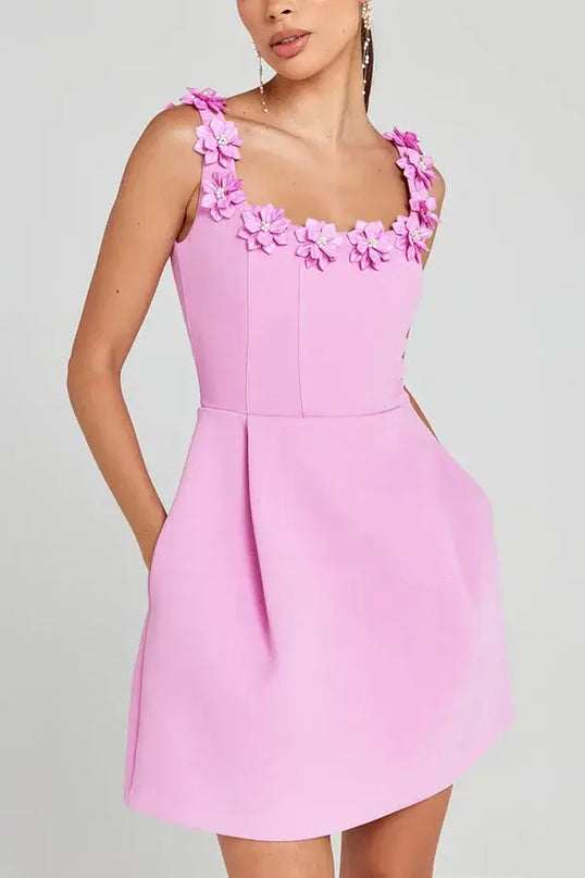 Pink dress with floral straps on a gray background