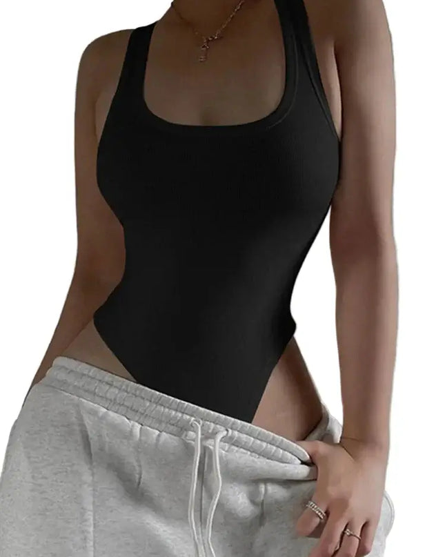 Person wearing a black bodysuit and gray sweatpants against a neutral background