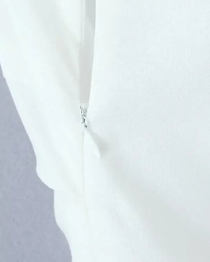 Close-up of zipper detail on a white cotton linen summer dress, showcasing quality craftsmanship.