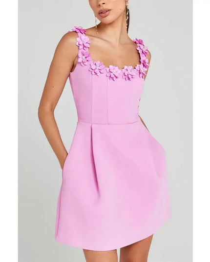 Pink dress with floral straps on a gray background