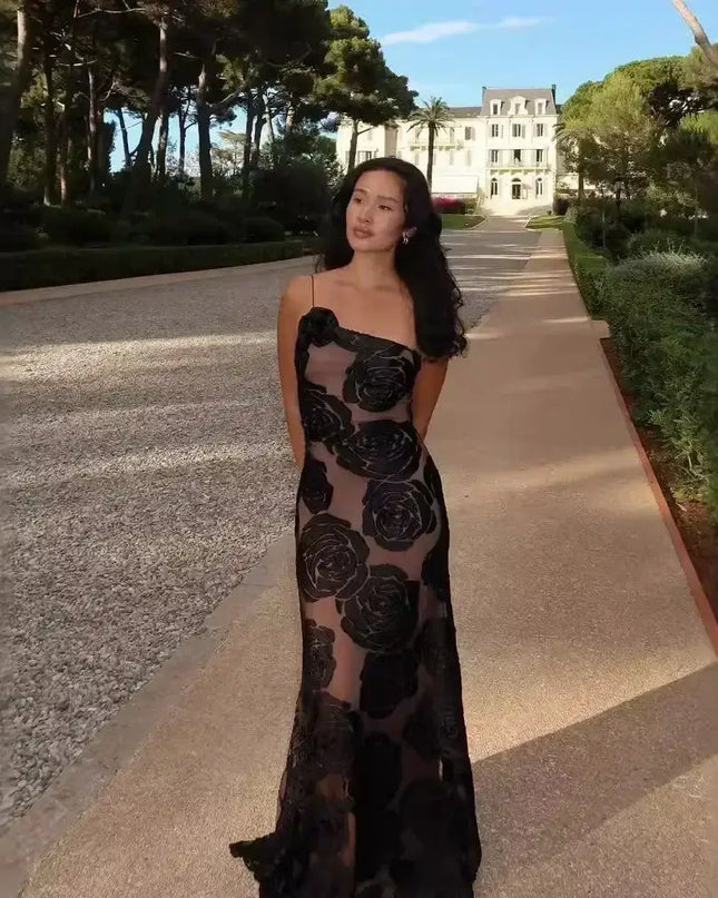 Oligai one shoulder elegant dress worn by a model in a beautiful outdoor setting, showcasing its sexy mesh design and floral pattern.