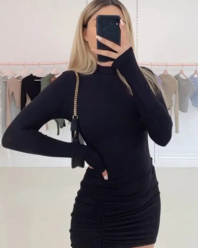 Women’s Long Sleeve Ruched Bodycon Turtleneck Mini Dress worn by model in a mirror selfie, featuring black fabric and stylish design.