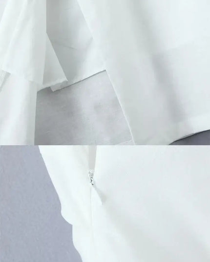 Close-up of the back area of a white cotton linen summer dress, showing fabric layers and zipper detail.