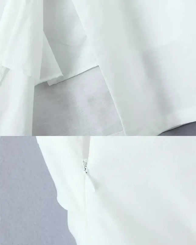 Close-up of the back area of a white cotton linen summer dress, showing fabric layers and zipper detail.