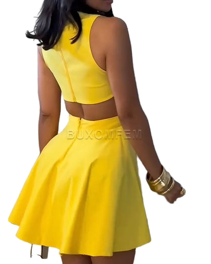 Woman wearing a yellow dress with cut-out design against a plain background