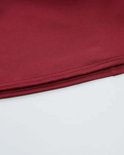 Close-up view of the hem and zipper of a burgundy off shoulder mini dress party, showcasing elegant fabric texture.
