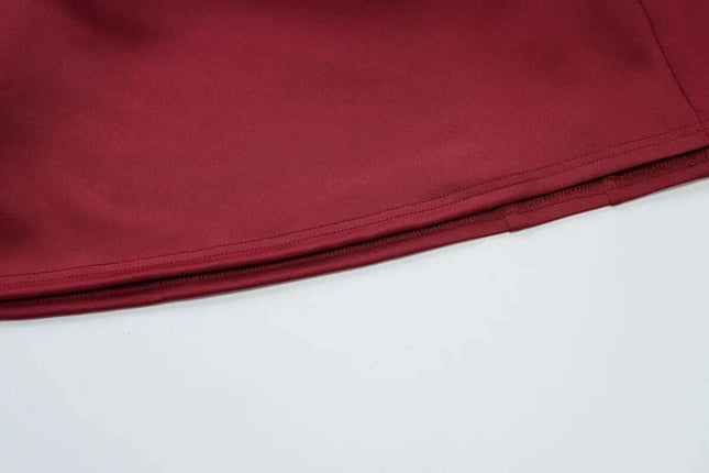 Close-up view of the hem and zipper of a burgundy off shoulder mini dress party, showcasing elegant fabric texture.