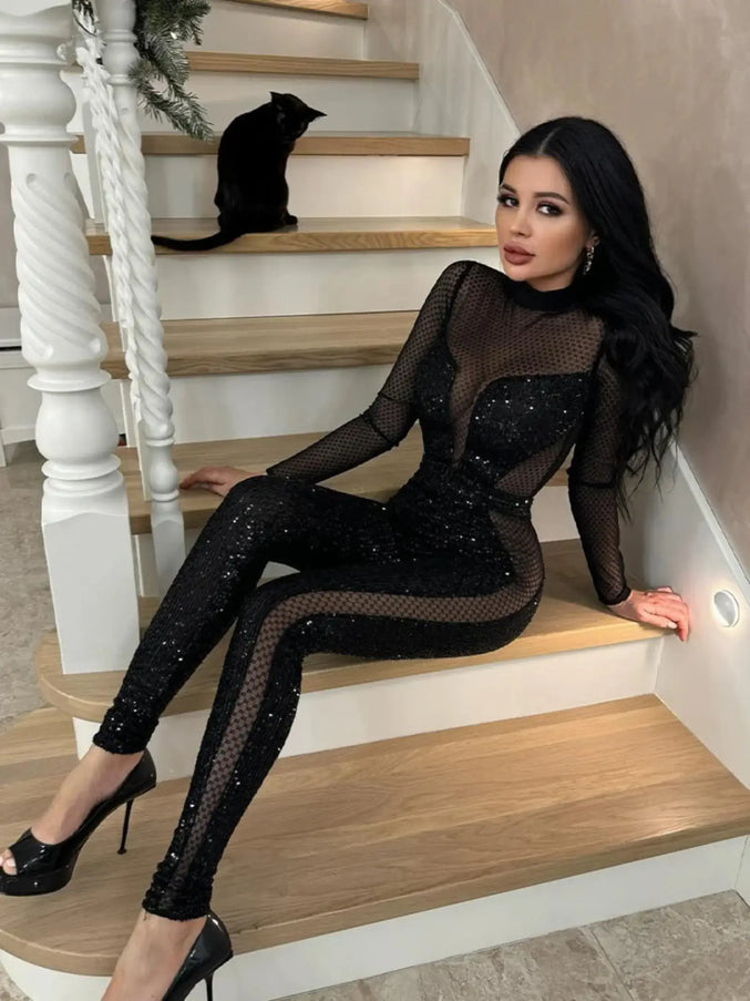 Woman in a black, sparkly outfit sitting on a staircase.