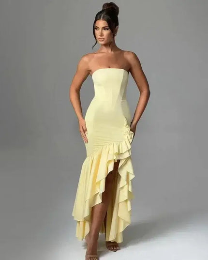 Stylish model wearing a sexy strapless summer dress with an asymmetrical hem in yellow.