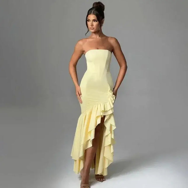 Stylish model wearing a sexy strapless summer dress with an asymmetrical hem in yellow.