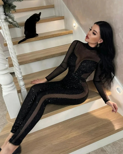 Woman in a black outfit sitting on a staircase with a cat on the steps.