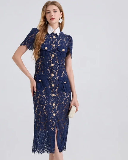 Woman wearing a navy lace dress with gold buttons on a light gray background