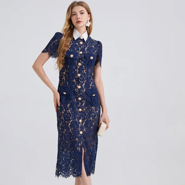 Woman wearing a navy lace dress with gold buttons on a light gray background