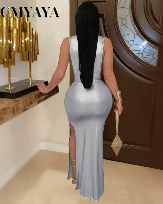 Back view of a woman wearing a silver CM.YAYA gilding cutout bodycon maxi dress featuring a thigh-high slit.