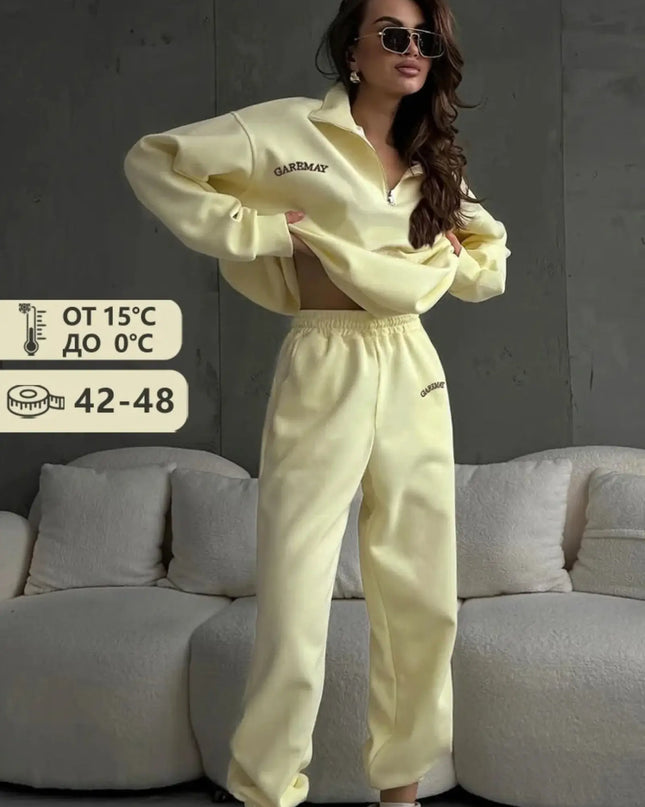 Woman wearing a light yellow tracksuit in a living room setting with temperature and size information displayed.