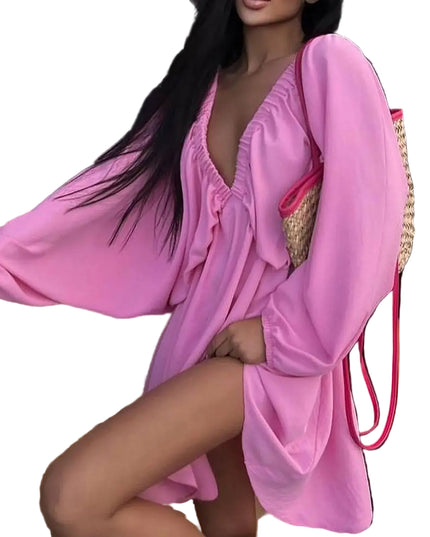 Model wearing a pink deep V-neck pleated dress with long sleeves and a stylish bag, showcasing a sexy retro vibe.