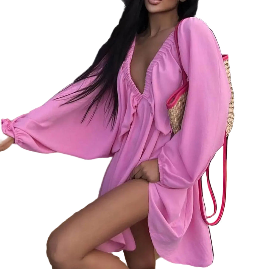 Model wearing a pink deep V-neck pleated dress with long sleeves and a stylish bag, showcasing a sexy retro vibe.