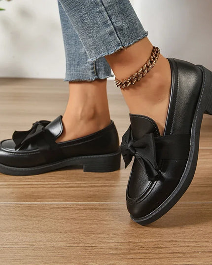 Bow tie loafers for women in black, featuring a stylish bow decoration and low-top design for fashionable everyday wear.