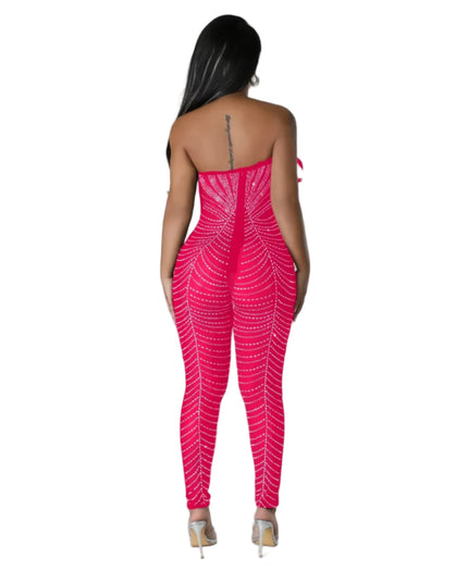 Woman wearing a bright pink strapless jumpsuit with a geometric pattern on a gray background