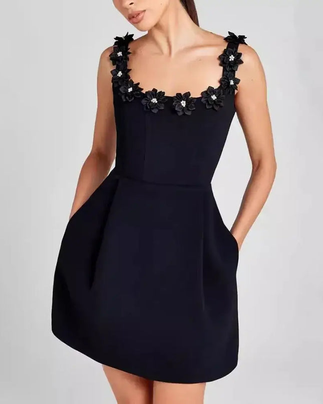 Black dress with floral embellishments on a plain background