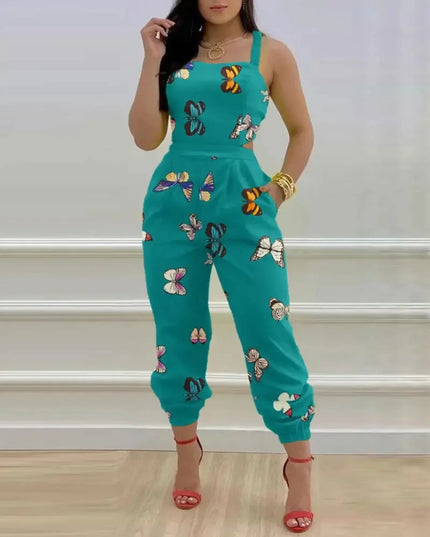Person wearing a teal jumpsuit with butterfly patterns against a white wall.