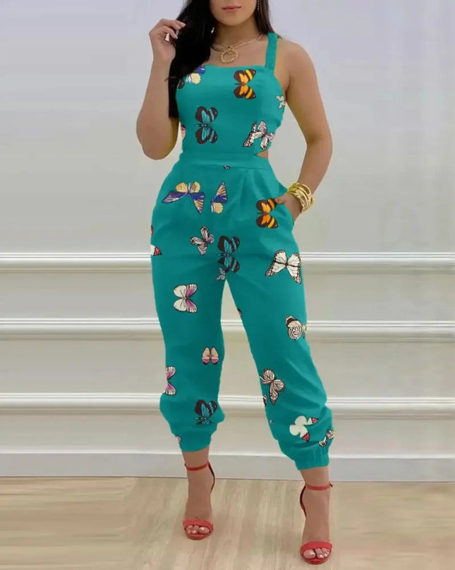 Person wearing a teal jumpsuit with butterfly patterns against a white wall.