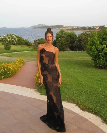 Oligai one shoulder elegant dress featured in a scenic outdoor setting near water, showcasing its sexy mesh design and bodycon fit.