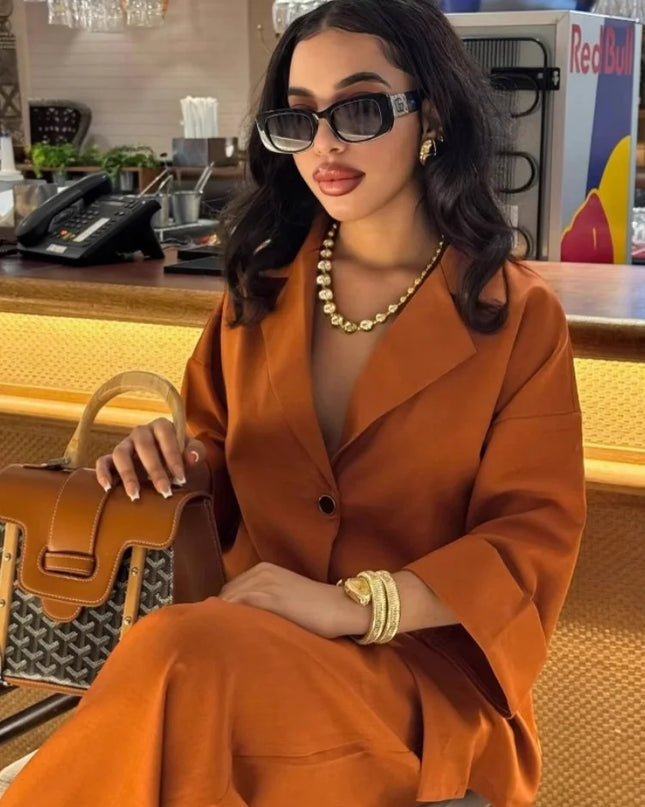 Women wearing a stylish orange women's casual suit with lapel shirt and high waist straight pants, accessorized with sunglasses.