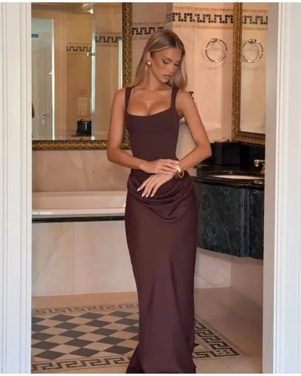 Model showcasing a brown pleated maxi dress square neck sleeveless gown in an elegant bathroom setting.