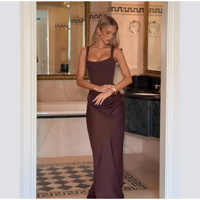 Model showcasing a brown pleated maxi dress square neck sleeveless gown in an elegant bathroom setting.