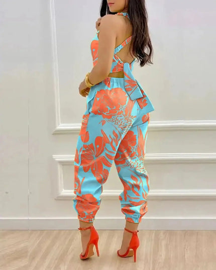 Woman wearing a colorful floral jumpsuit with high heels in a room.
