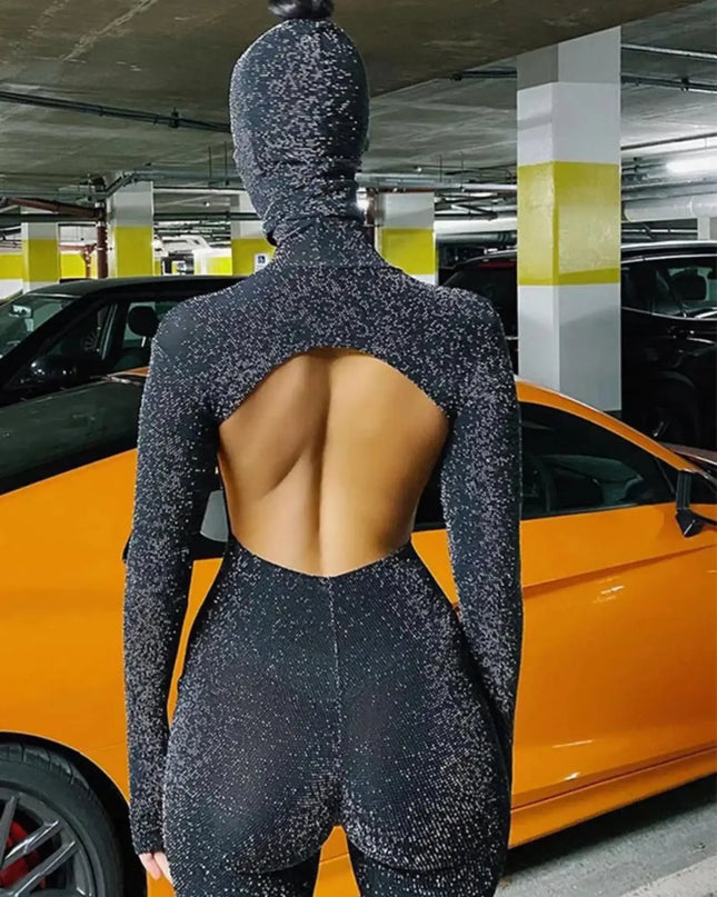Person wearing a black textured outfit with an open back in a parking garage.