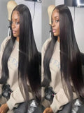 Person with long black hair styled in a sleek manner, wearing a beige sweatshirt.