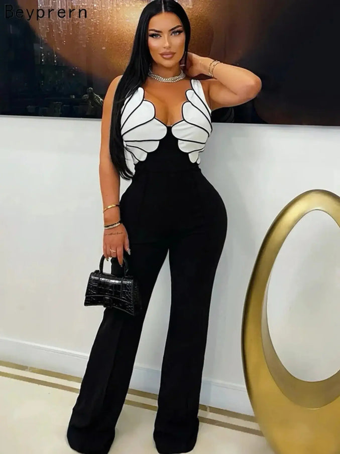 Woman wearing a black and white outfit with butterfly wings, holding a black handbag.