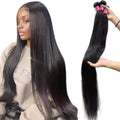 Woman with long straight hair and a bundle of hair extensions on a white background