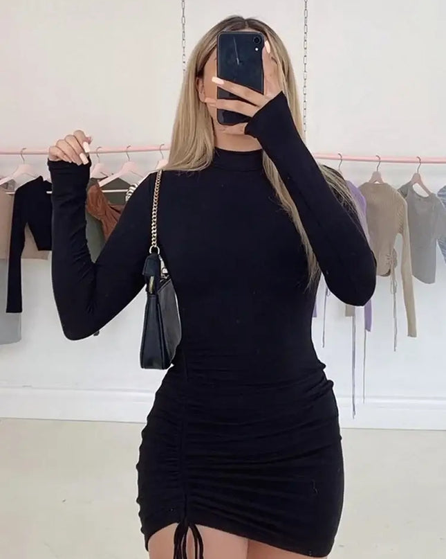 A model wearing a Women’s Long Sleeve Ruched Bodycon Turtleneck Mini Dress in black, showcasing its chic design.