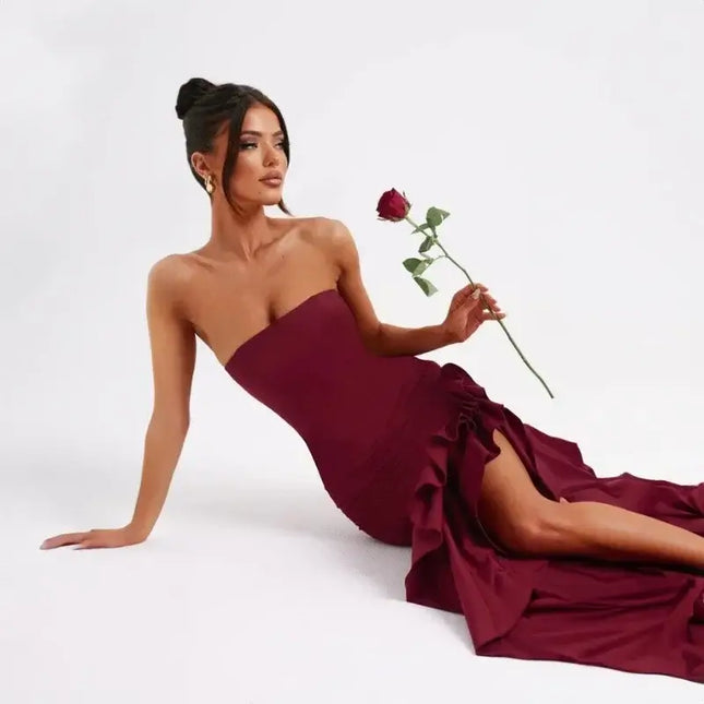 Sexy strapless summer dress in burgundy worn by a model holding a rose, showcasing an elegant irregular design.