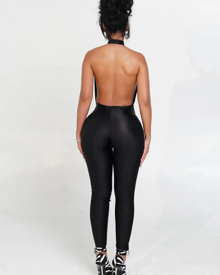Person wearing a black open-back jumpsuit on a white background