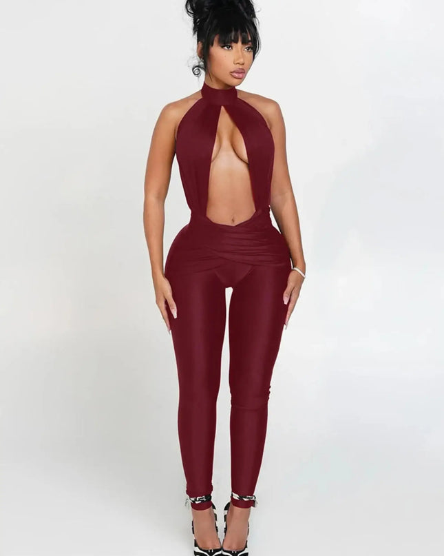 Woman wearing a burgundy jumpsuit with a halter neck design on a white background