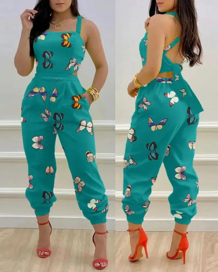 Teal jumpsuit with butterfly patterns worn by a model indoors.