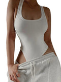 Person wearing a white tank top and gray sweatpants against a neutral background